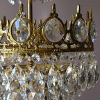 Close view of the pierced brass crown with clear crystal ovals and teardrops on this Clérachic chandelier.