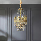 Smaller Clérachic chandelier against a grey panelled wall, with a gold-wrapped chain and a crown ring of clear crystals.