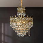 Clérachic crystal chandelier against a dark grey wall, its two crown tiers and layered crystals lit warmly.