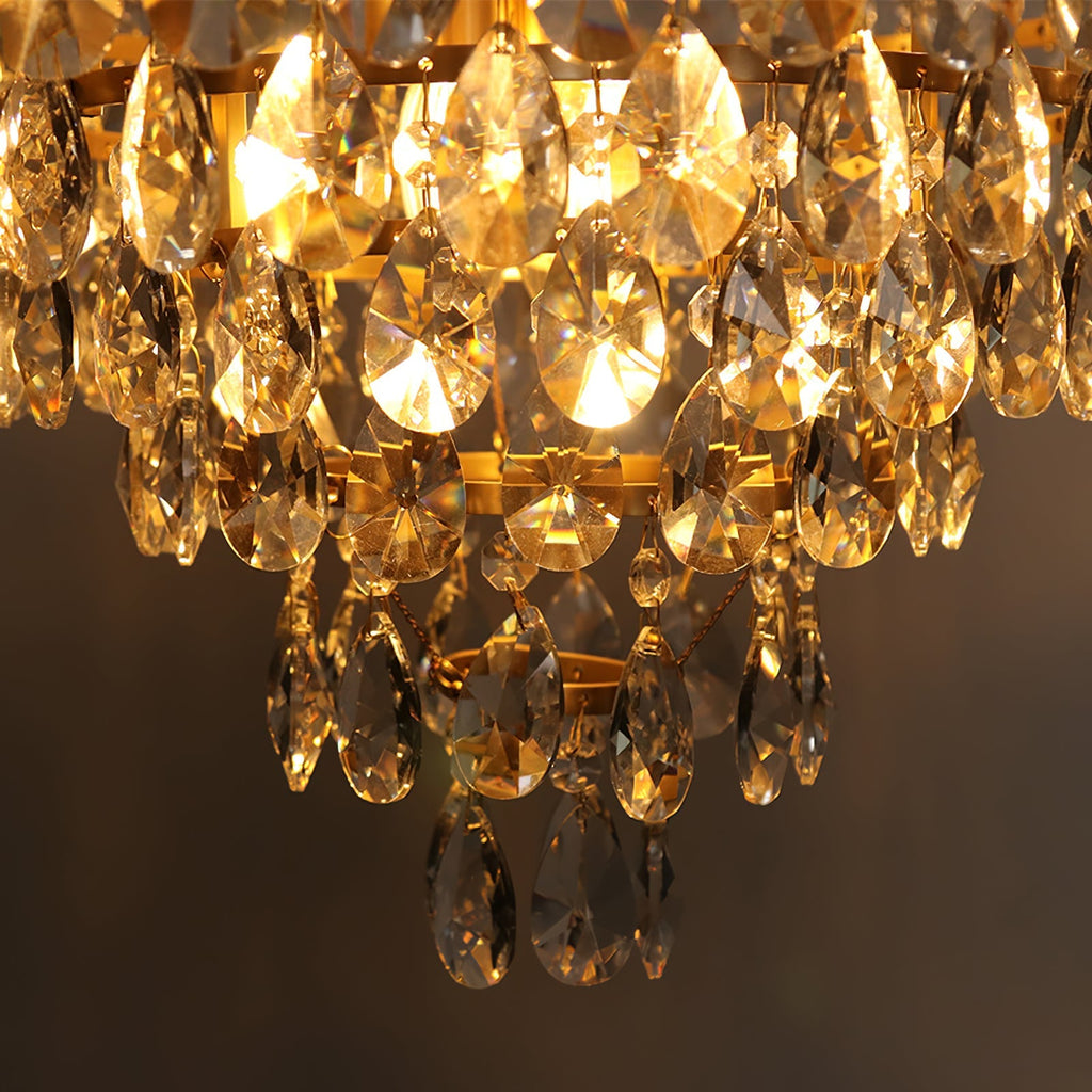 Close view of the lit lower tiers of this Clérachic chandelier, with amber light through the crystal drops.