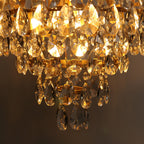 Close view of the lit lower tiers of this Clérachic chandelier, with amber light through the crystal drops.