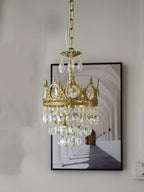 Smaller Clérachic chandelier hung before a black-framed print of an arched corridor, on a pale wall.