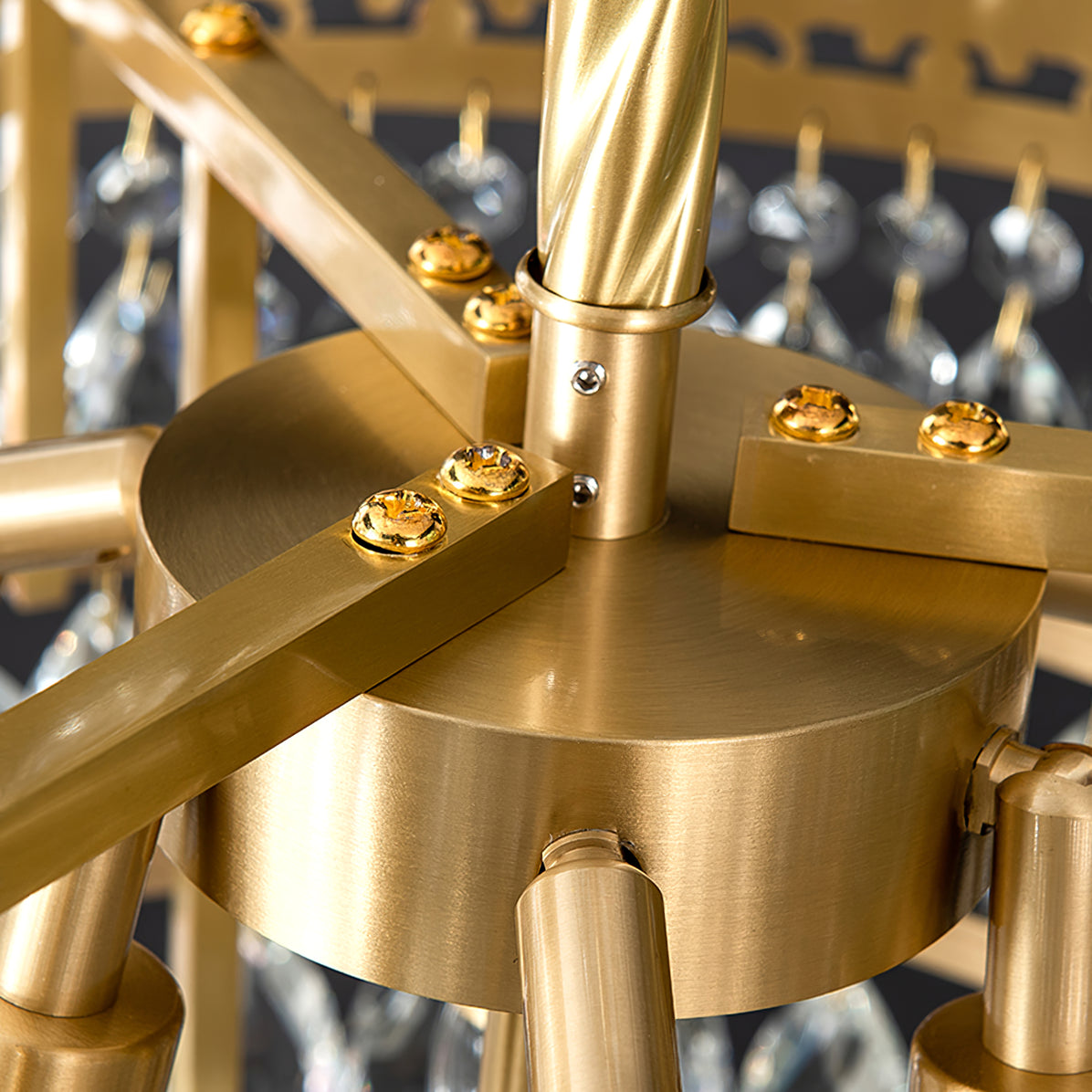 Close view of the brushed brass hub and twisted stem where the arms meet on this Clérachic chandelier.