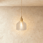 Clérachic Isabel pendant light, a fine vertically-ribbed clear glass dome shade glowing warm on a brass fitting.