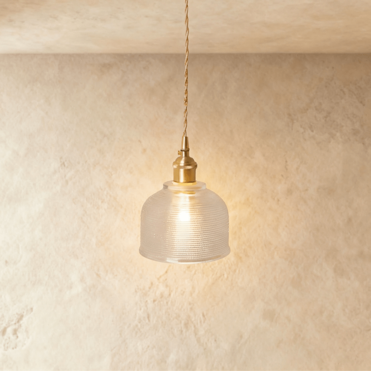 Clérachic Isabel pendant light, a fine vertically-ribbed clear glass dome shade glowing warm on a brass fitting.