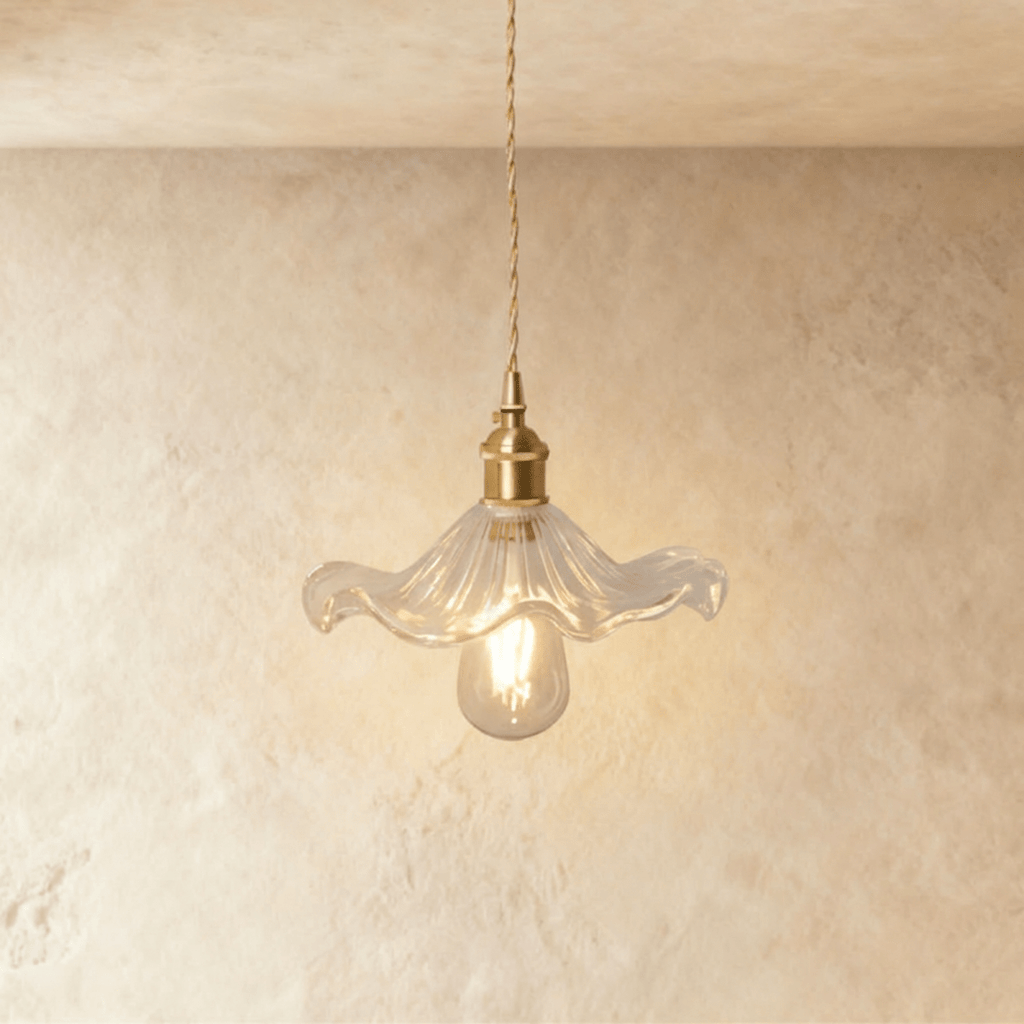 Clérachic Isabel pendant light, a wide scalloped clear glass petal shade sitting flat under a warm brass fitting.