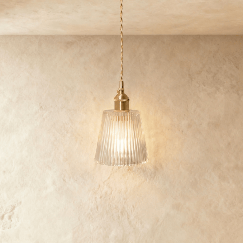 Clérachic Isabel pendant light, a tapered clear glass cone shade with fine vertical ribbing glowing warm white.