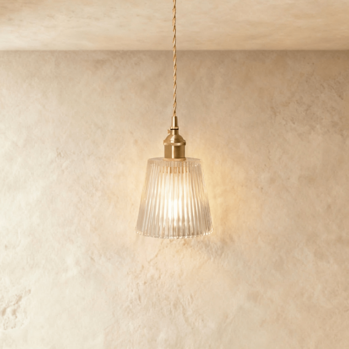 Clérachic Isabel pendant light, a tapered clear glass cone shade with fine vertical ribbing glowing warm white.
