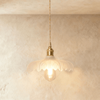 Clérachic Isabel pendant light, a ruffled clear glass flower shade with pointed scalloped petals and an exposed bulb.