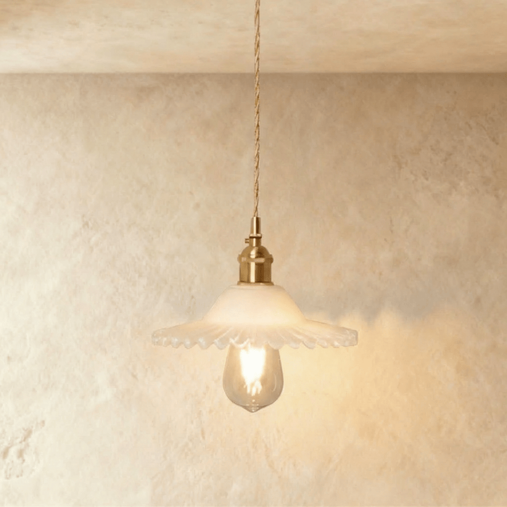 Clérachic Isabel pendant light, a ruffled opal white glass flower shade glowing softly around an exposed bulb.