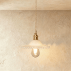 Clérachic Isabel pendant light, a ruffled opal white glass flower shade glowing softly around an exposed bulb.