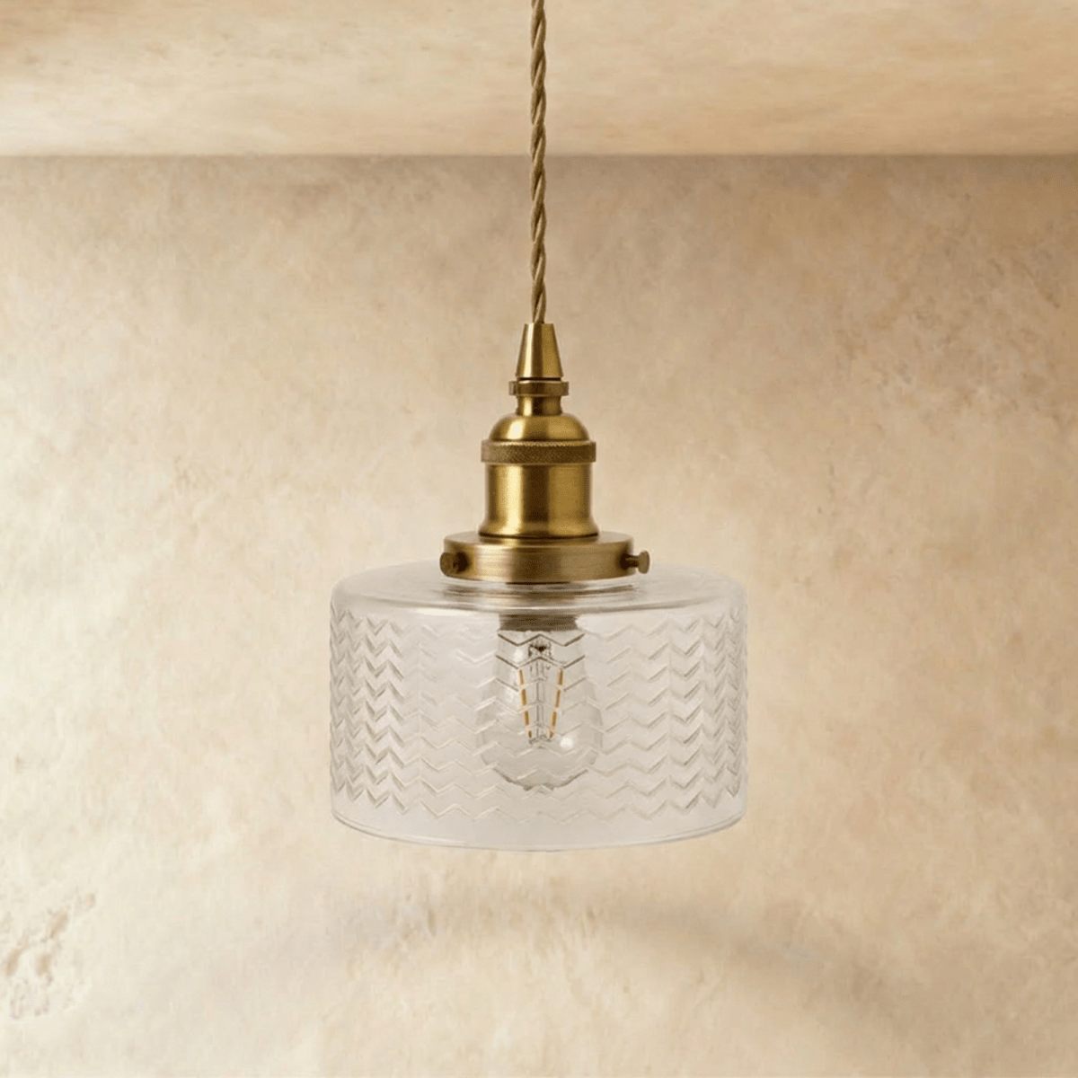 Clérachic Isabel pendant light, a compact clear glass drum shade with a fine chevron texture glowing warm white.