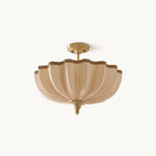 This Clérachic semi-flush ceiling light on a plain white backdrop, a pleated cream shade with a scalloped braided edge and a brass-toned stem.