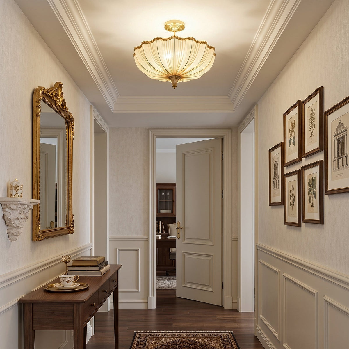 Seen from the far end of a hallway, a Clérachic ceiling light hangs above a console table, a gilt mirror and a row of framed prints.