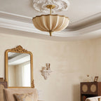 Clérachic ceiling light below a decorative white ceiling rose, with a tall gilt mirror and a small cabinet in a cream room.