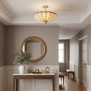 Clérachic ceiling light in a grey-taupe entrance hall, above a white console table with a round brass-framed mirror.
