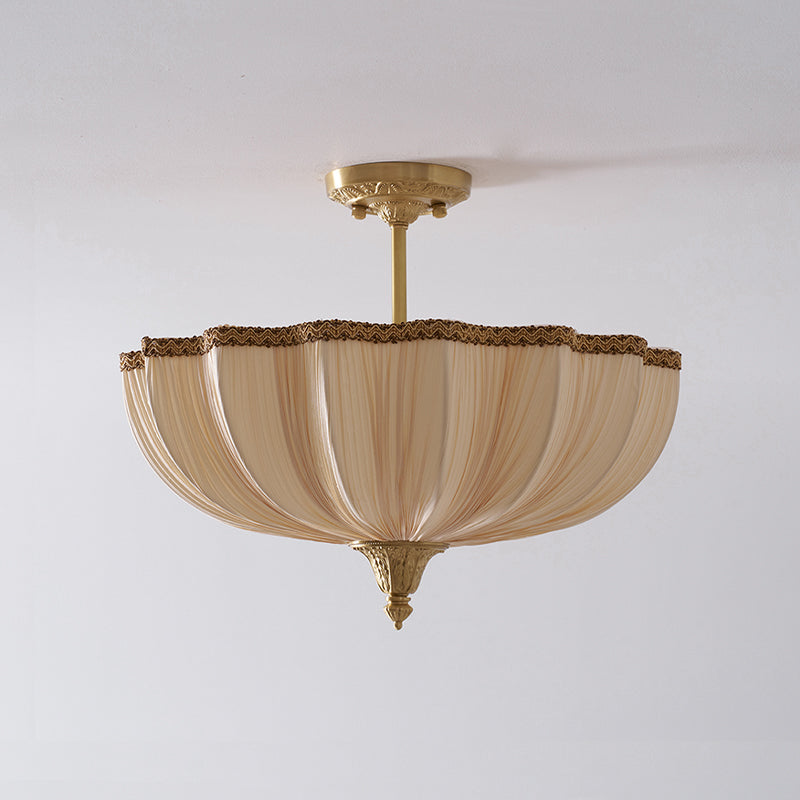 Unlit Clérachic ceiling light on a pale ceiling, showing the pleated cream shade hanging from a brass rod and decorative ceiling plate.
