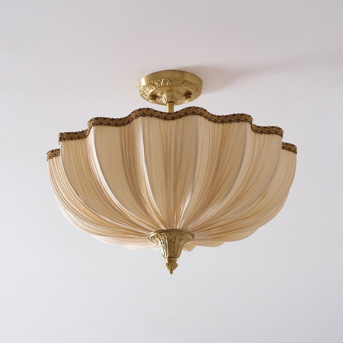 Clérachic semi-flush light, unlit, on a pale ceiling, the pleated cream fabric folded in soft vertical ribs.