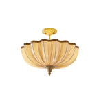 Clérachic semi-flush ceiling light on a white background, with its pleated cream shade, braided edge and bright brass ceiling plate.