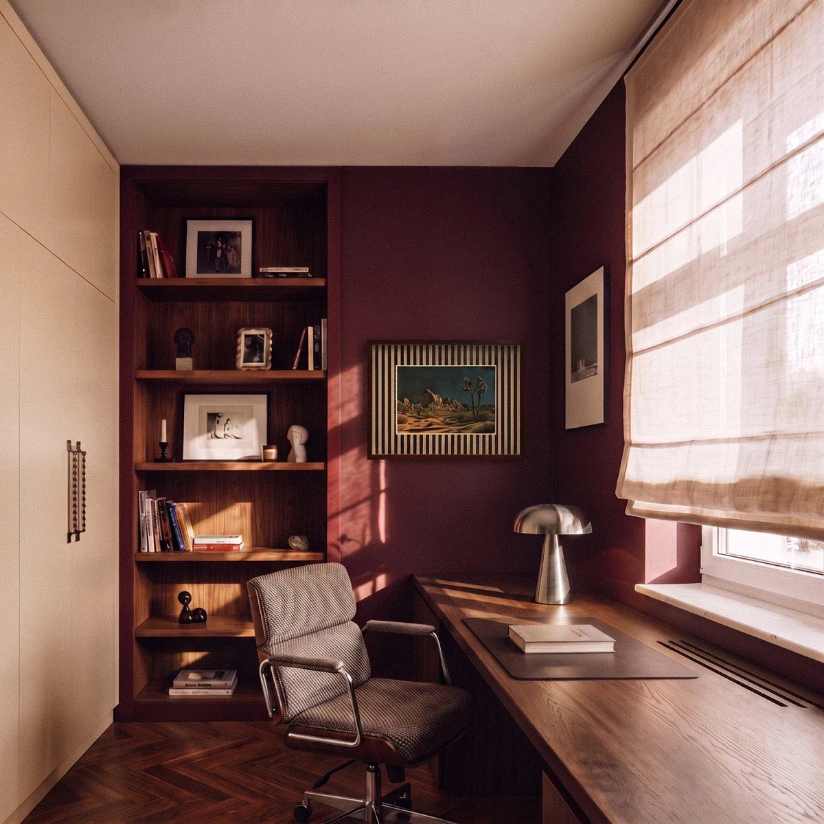 Clérachic silver table lamp lit on a walnut desk in a burgundy home office with a Joshua Tree print nearby.