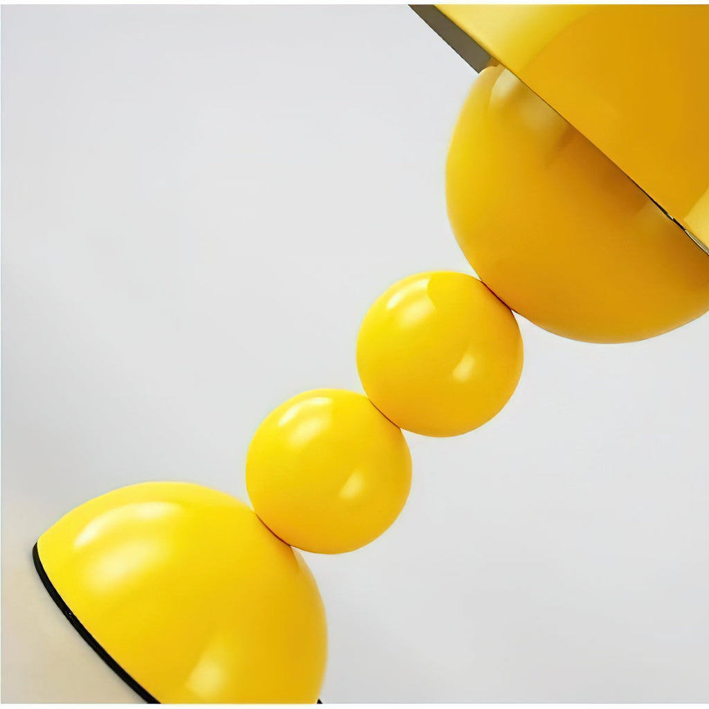 Close view of the glossy yellow stacked spheres and the base dome on this Clérachic table lamp.