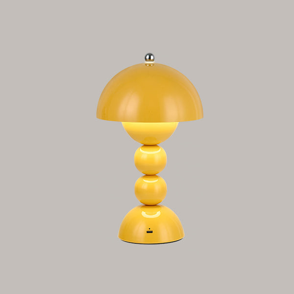 Yellow Clérachic dome lamp with a lit inner glow and a small charging port at the base, on a grey backdrop.
