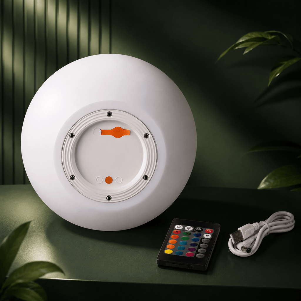The Clérachic orb lamp's underside with its charging port, beside a remote and USB cable.