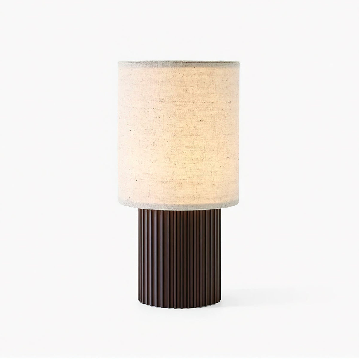 Front view of this Clérachic table lamp on white, the beige linen shade glowing above a vertically ribbed brown base.