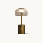 Cordless table lamp from Clérachic with a crackle glass dome shade on a slim bronze stem and a round bronze base, on a plain white backdrop.