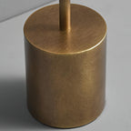 Close view of the brushed bronze base of this Clérachic table lamp, with the slim stem rising from its flat top.