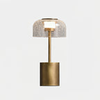 The Clérachic table lamp unlit and cut out, with its crackle glass dome, bronze stem and round base on a white background.