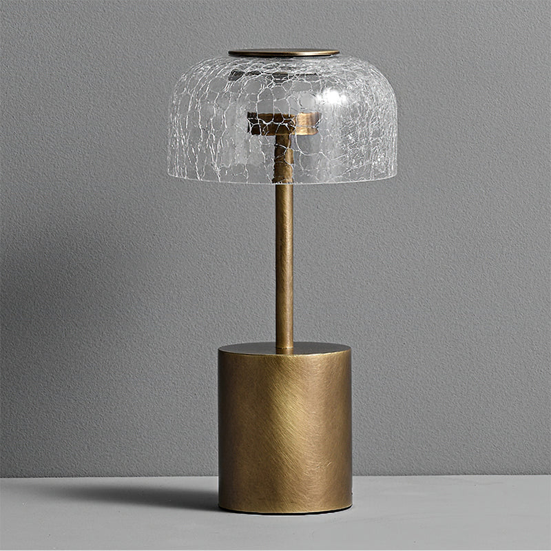 Front view of the unlit Clérachic table lamp, showing the crackle glass dome, the bronze stem and the brushed round base.