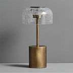 Front view of the unlit Clérachic table lamp, showing the crackle glass dome, the bronze stem and the brushed round base.