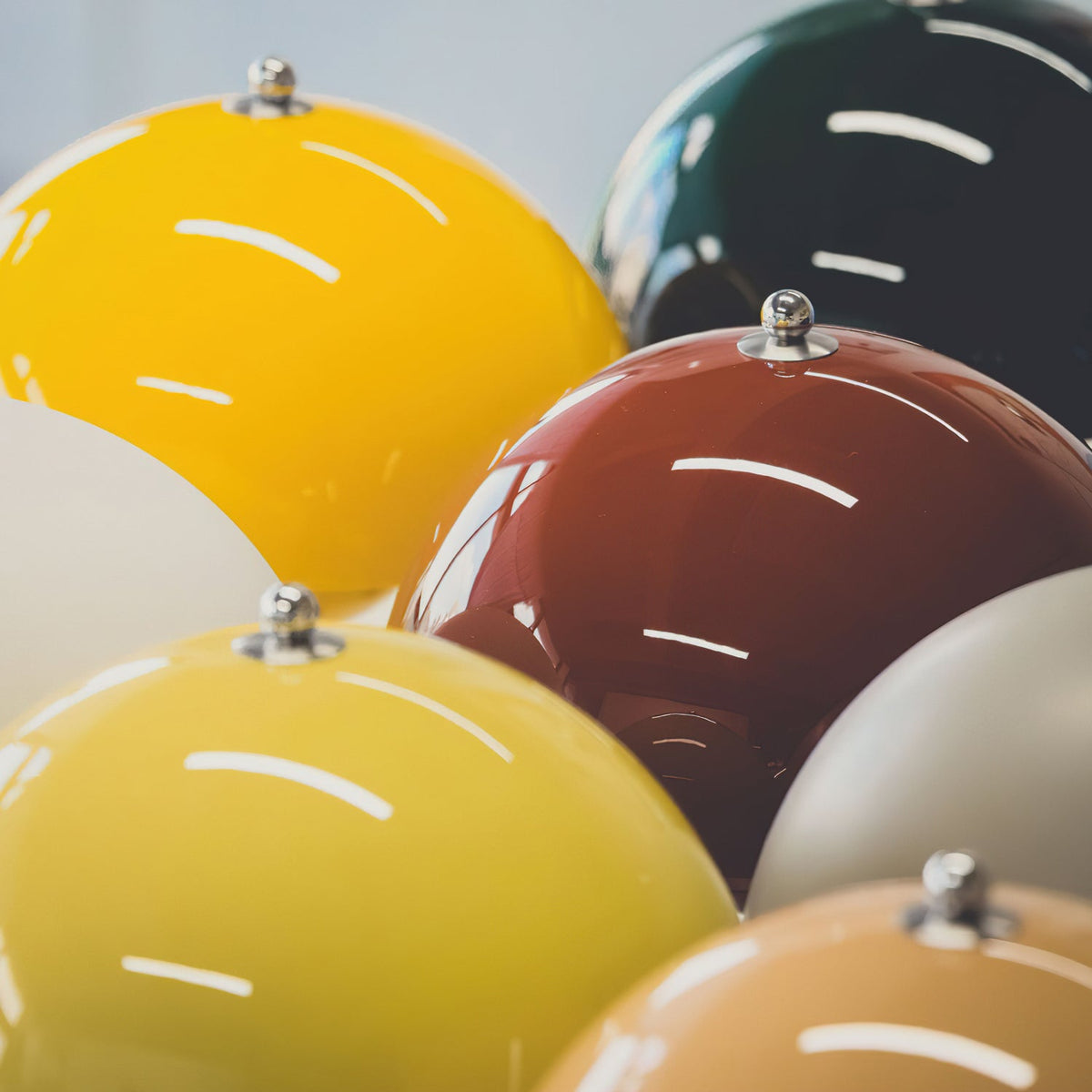 Close view of glossy dome shades in yellow, burgundy, green and grey on these Clérachic table lamps.