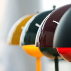 Close view of yellow, green and burgundy dome shades from these Clérachic table lamps, with the light glowing below.