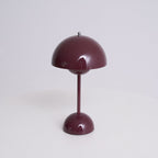 Front view of this Clérachic table lamp in deep plum, on a soft grey backdrop, with a glossy dome shade and slim stem.