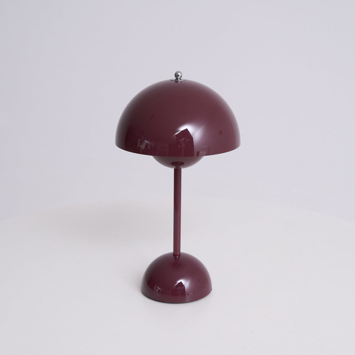 Front view of this Clérachic table lamp in deep plum, on a soft grey backdrop, with a glossy dome shade and slim stem.