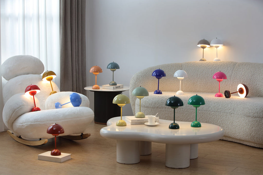 A living room with many small Clérachic table lamps in different colours on the sofa arms, side tables and coffee table.