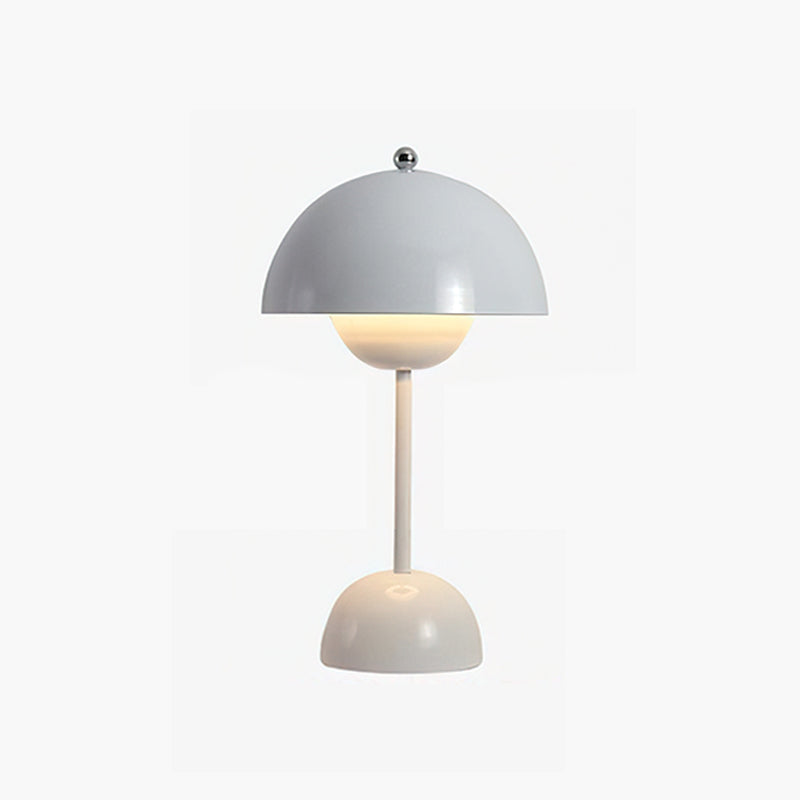A pale grey Clérachic table lamp lit, with a slim cream stem and rounded base, on a white backdrop.