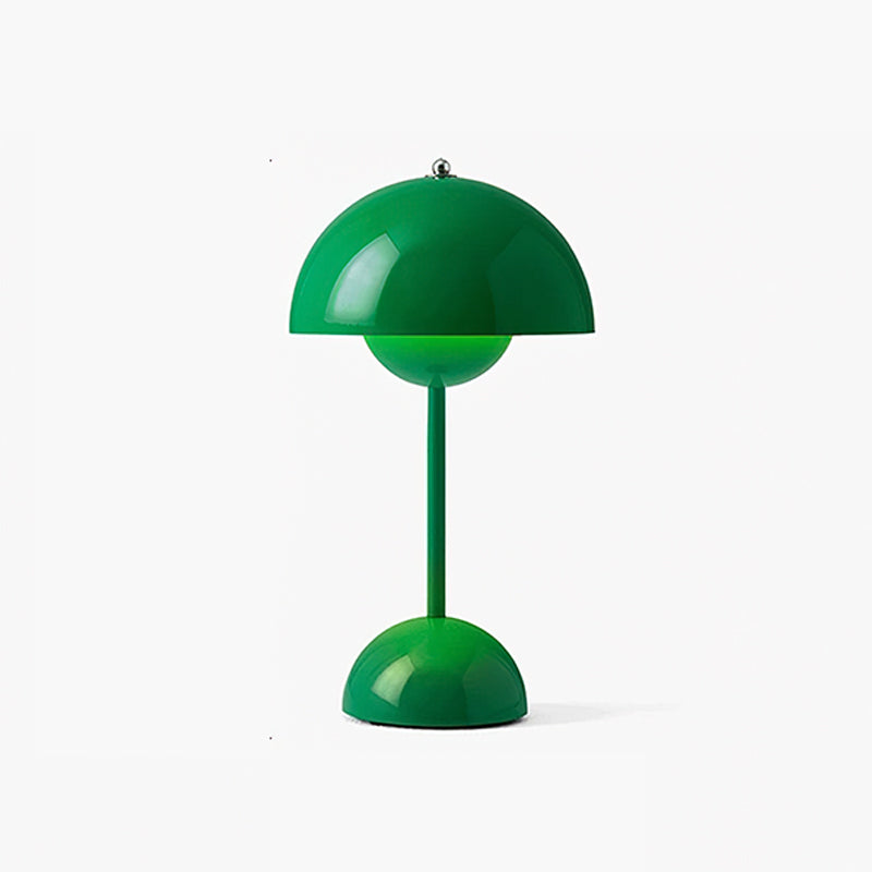 A bright green Clérachic table lamp lit, with a glossy dome shade and a rounded base, on a white backdrop.