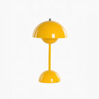 A yellow Clérachic table lamp, with a glossy dome shade and a rounded base, on a plain white backdrop.
