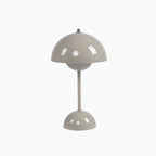 A greige Clérachic table lamp with a glossy dome shade and a rounded base, on a plain white backdrop.