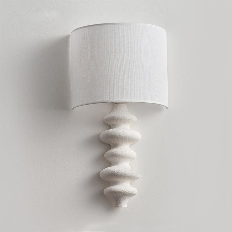 Unlit white linen half-drum shade on a Clérachic wall light, over a white textured column, on a pale grey wall.