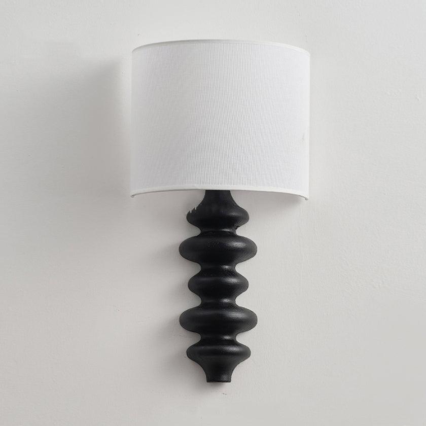 Clérachic wall light switched off, with a white linen shade over a black corrugated wooden column on a light wall.