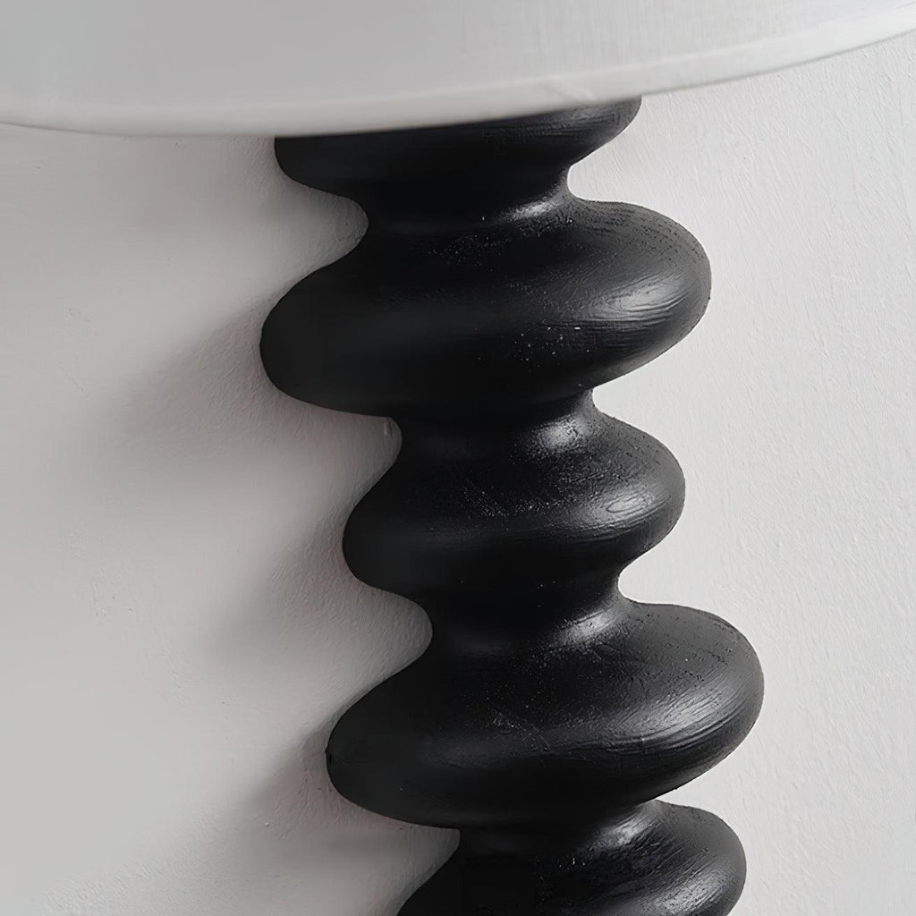 Close view of the black corrugated wood column on this Clérachic wall light, with brush marks visible on the rounded ridges.