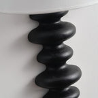Close view of the black corrugated wood column on this Clérachic wall light, with brush marks visible on the rounded ridges.