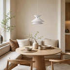 Paler, unlit look of this Clérachic pendant light above a round oak table with bowls and a cushioned window bench.