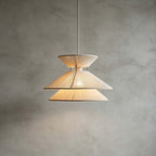 Close view of the two cotton-wrapped tiers of this Clérachic pendant light, glowing on a grey plaster wall.