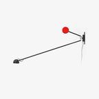 Clérachic counterweight wall light on a plain white backdrop, a long black arm reaching down to a small lamp head, red disc counterweight above.