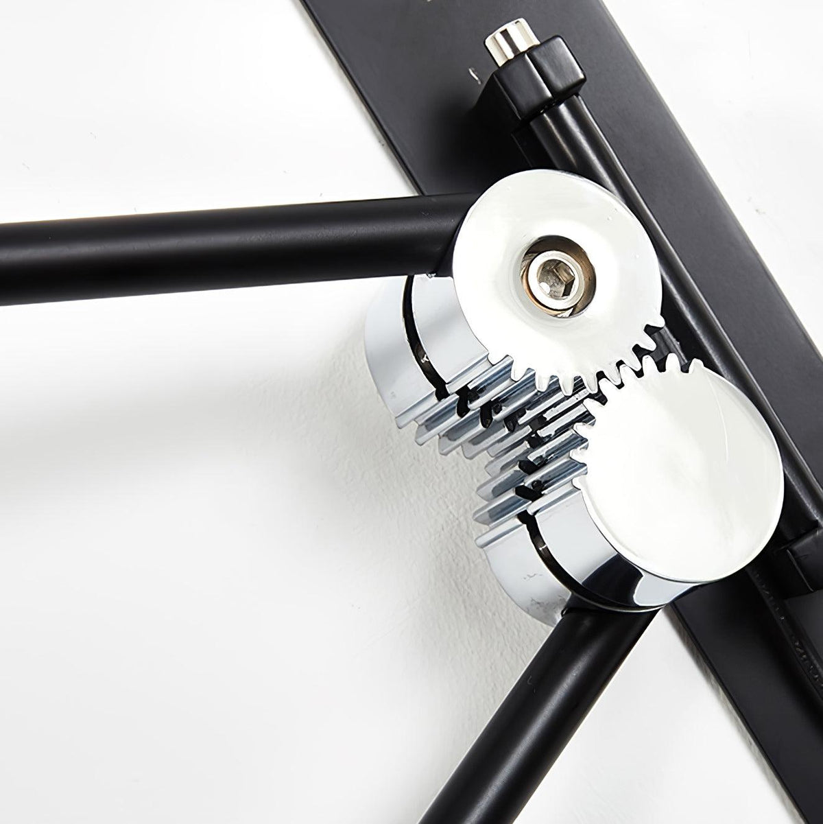 Close view of the chrome gear joint and black arm bracket on the wall mount of this Clérachic wall light.
